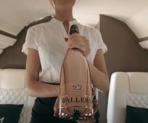 BALLERS CHAMPAGNE ROSE GOLD CHROME EXTRA BRUT ROSÉ BEING SERVED ON A PRIVATE JET